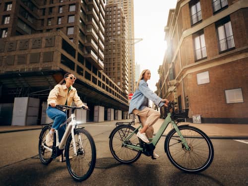 Zwei junge Frauen fahren E-Bike in der Grossstadt