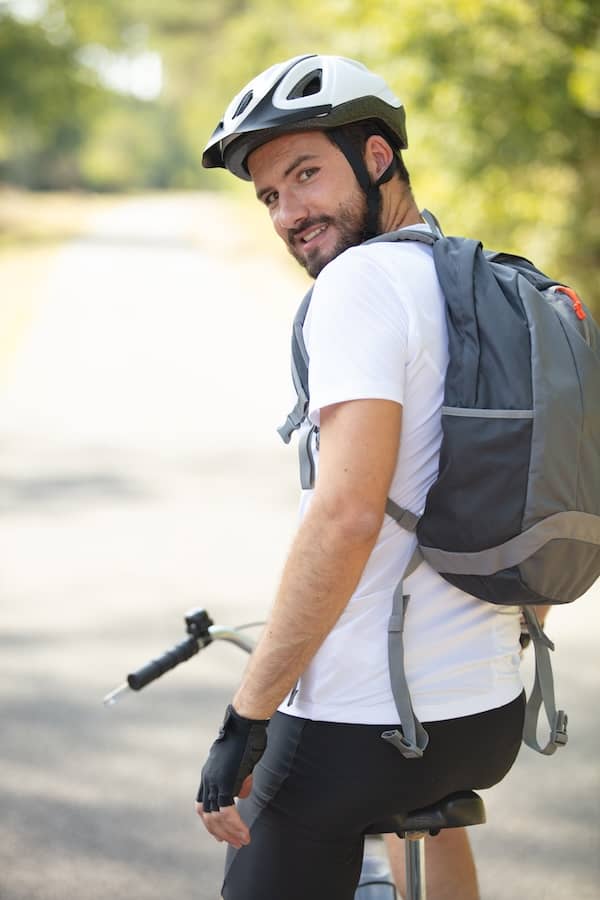 Radfahrer mit Betriebsfahrrad und Helm Blickt Sich Um