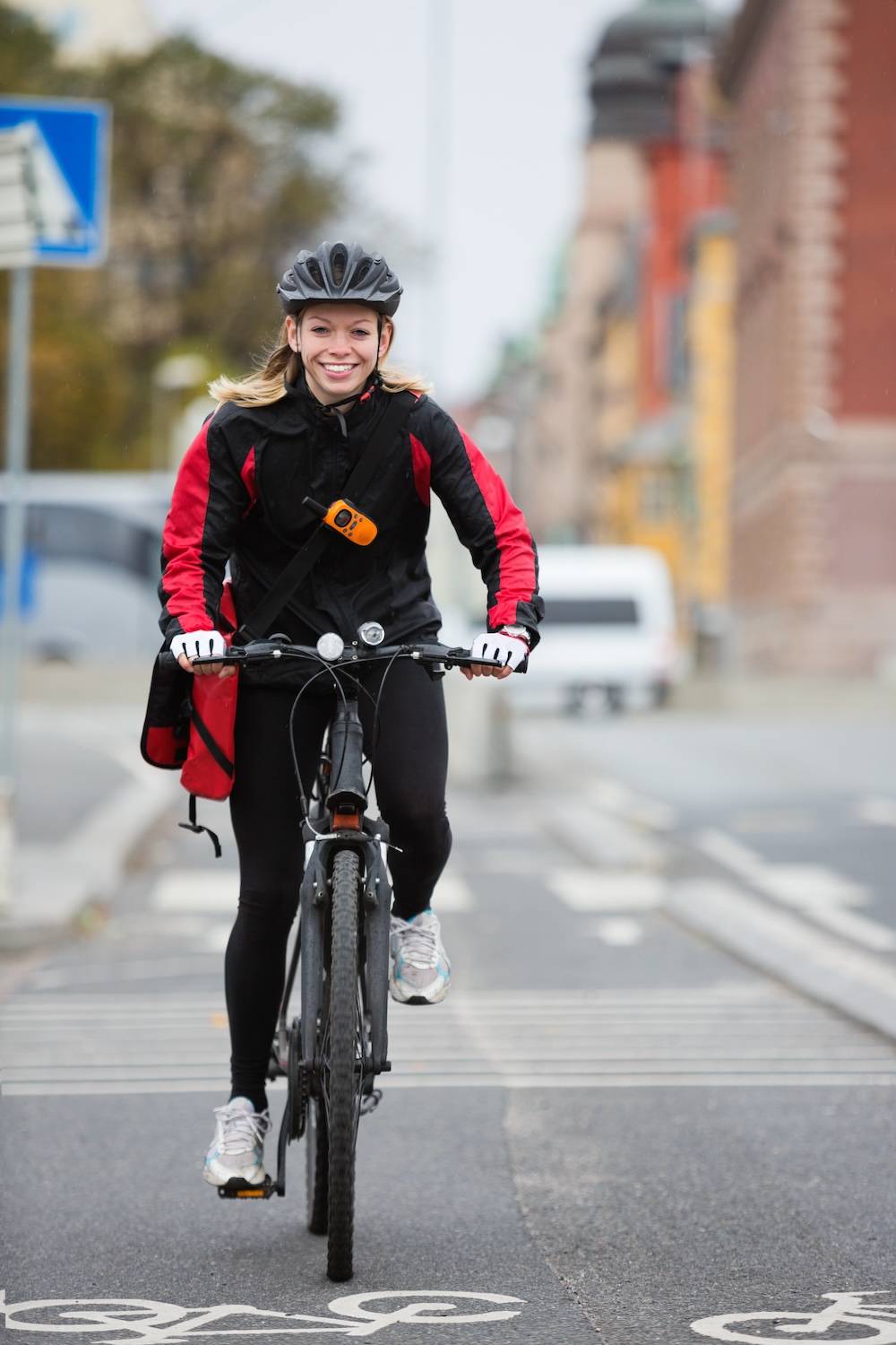 Junge Frau fährt als Courier durch die Stadt