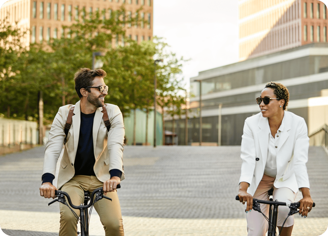 couple with sunglasses on bikes next to each other in urban surrounding bike leasing