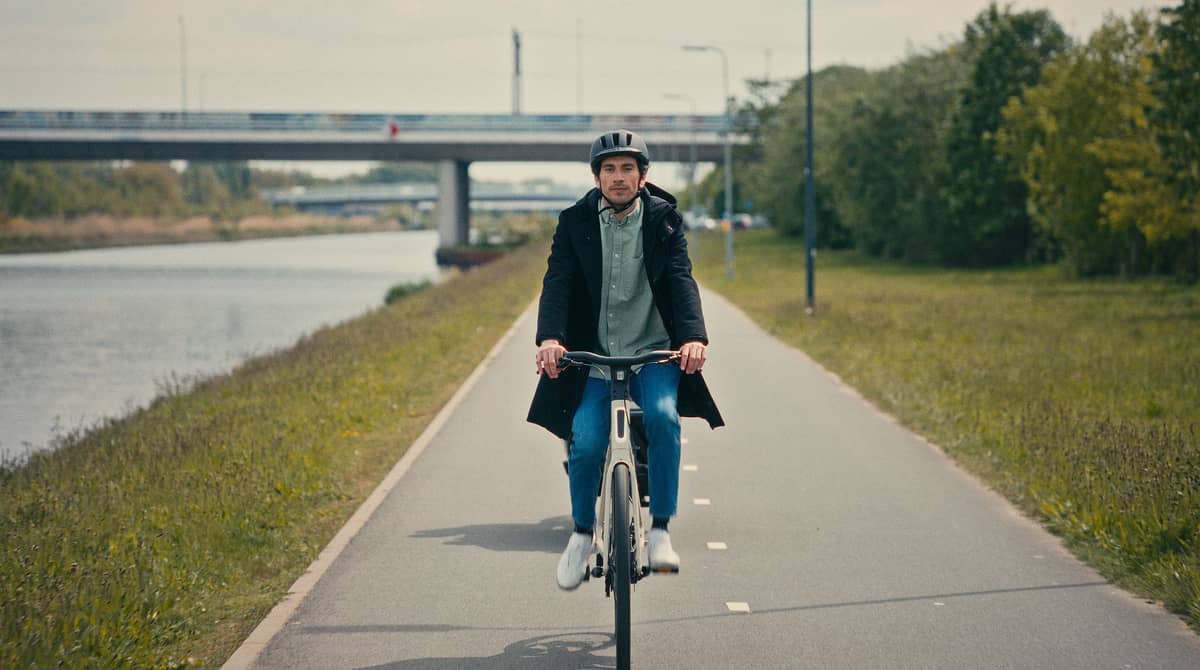 Mann auf Fahrrad an Fluss