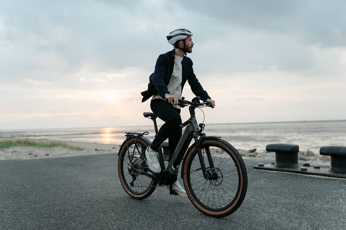 man riding his bike near the beach