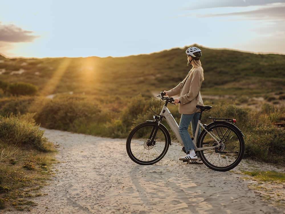 woman standing with bike in dunes